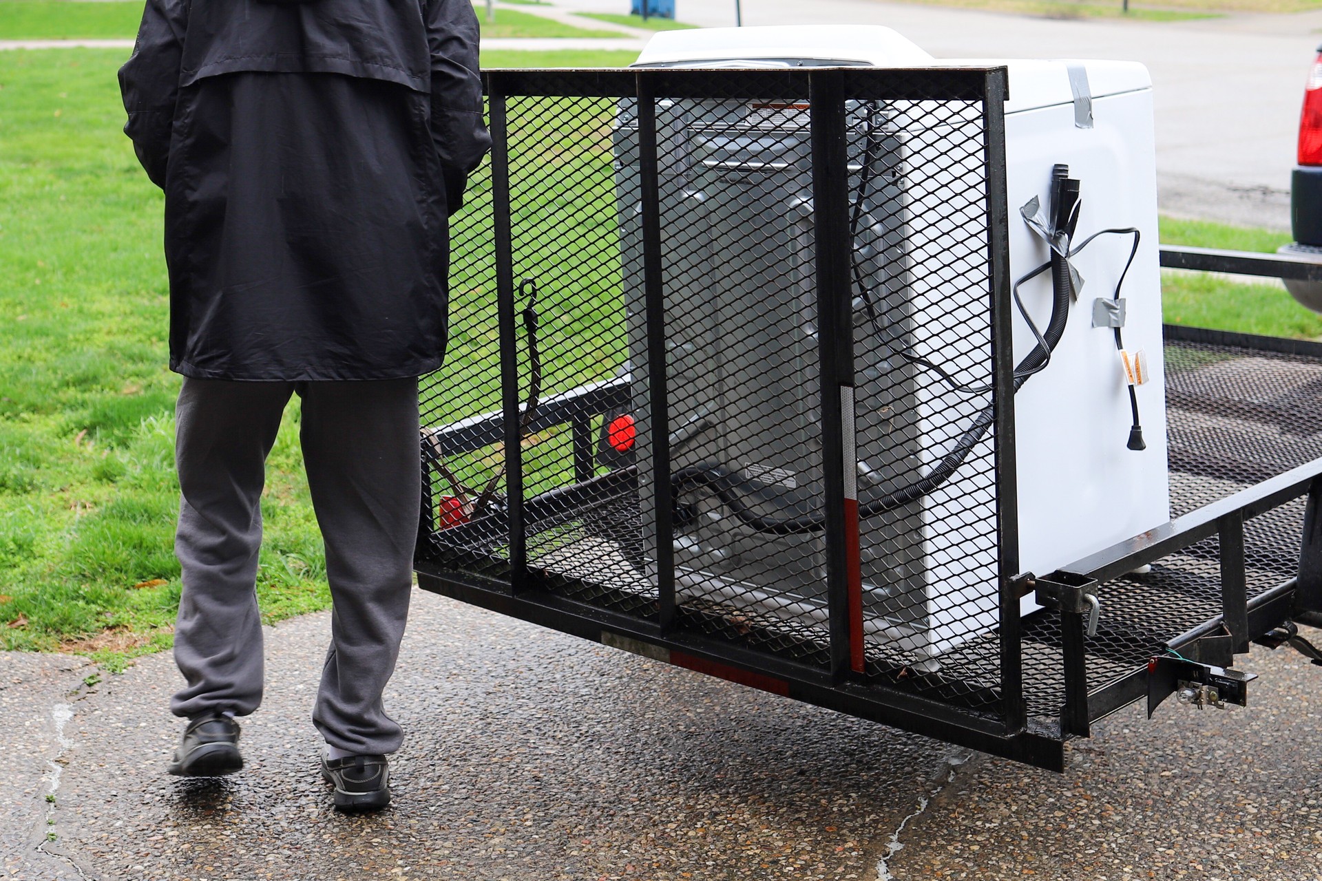 A black African-American man delivering a washing machine on a truck